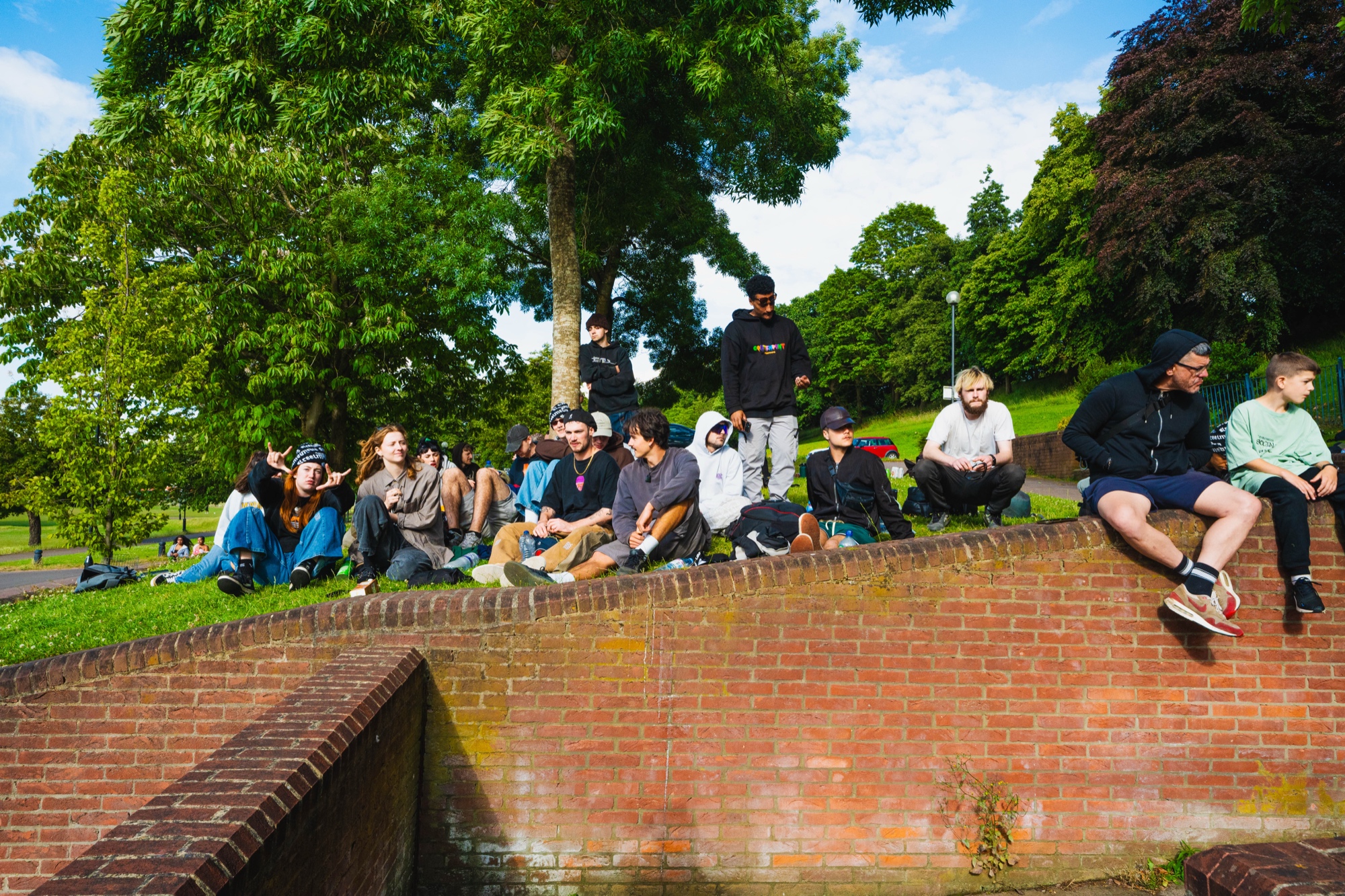 The StreetMedia community sitting together on a brick wall in Nottingham