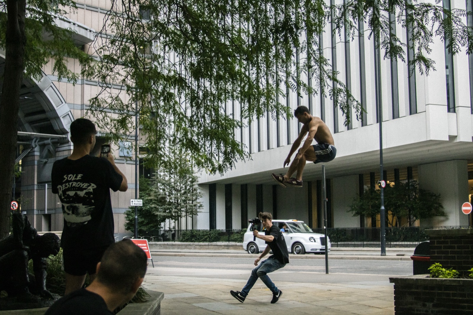 Urban parkour session with an athlete mid-air while others watch and film